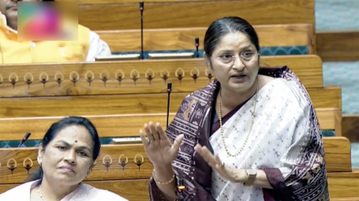 Annpurna Devi stands and speaks in the Lok Sabha chamber, gesturing with both hands, a colleague seated in front